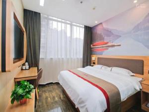 a hotel room with a large bed and a tv at Thank Inn Chain Hotel Shaanxi Baoji Qishan County Zhouwu Road Store in Baoji