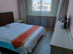 a bedroom with a large bed and a window at JUN Hotels Yulin Yuyang District Xinlou Store in Yulin