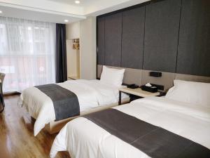 ein Hotelzimmer mit 2 Betten und einem Fenster in der Unterkunft Thank Inn Plus Hotel Sichuan Guang'an Yuechi County Tianlong Street Store in Guang'an