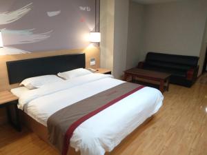 a hotel room with a large bed and a couch at Thank Inn Chain Hotel Qinghai Yushu County Kangba Commercial City in Yushu