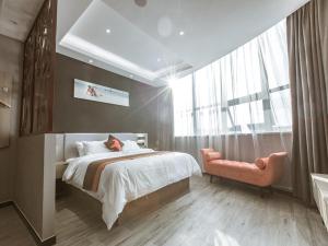 ein Schlafzimmer mit einem großen Bett und einem Fenster in der Unterkunft JUN Hotels Jiangsu Wuxi East Railway Station Store in Zhaqiao