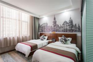 duas camas num quarto de hotel com um desenho na parede em Thank Inn Chain Hotel Shanxi Taiyuan Wanbolin District Wanxiang City em Taiyuan