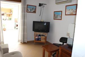 a living room with a tv on a wall at Dom Fernando I in Loulé