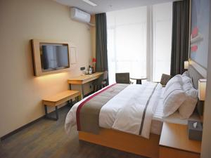 una camera d'albergo con un grande letto e una TV di Thank Inn Chain Hotel Huaihua Tongdao Bus Station a Tongdao