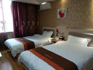 a hotel room with two beds and a window at JUN Hotels Anhui Suzhou Lingbi County Riyue Star City Laidi Shopping Street Store in Suzhou