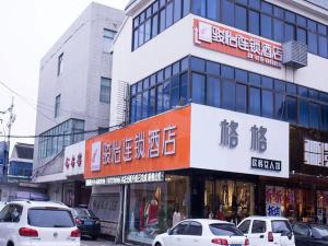 une rue avec des voitures garées devant un bâtiment dans l'établissement JUN Hotels Jiangsu Wuxi Jiangyin Changjing Coach Station Store, à Wuxi