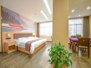a bedroom with a bed and a table and chairs at Thank Inn Chain Hotel Hunan Hengyang Nanyue District Hengshan Road Nanyue Temple in Hengyang