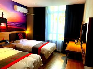 a hotel room with two beds and a painting of a giraffe at JUN Hotels Tianjin Jinnan District University City Pingfan Road in Tianjin