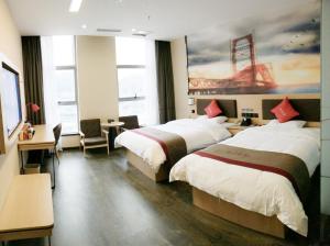 a hotel room with two beds and a painting on the wall at Thank Inn Plus Hotel Guizhou Qiannan Duyun Wanda Plaza Store 