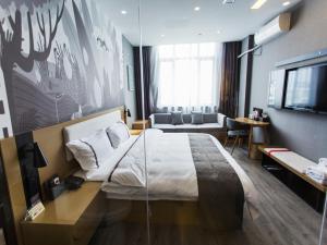 a hotel room with a large bed and a television at Thank Inn Chain Hotel Zhejiang Huzhou Deqing County Xinshi Town Huancheng West Road in Huzhou