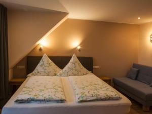 ein Schlafzimmer mit einem Bett und einem Sofa in der Unterkunft Das Gästehaus in Valwig in Valwig
