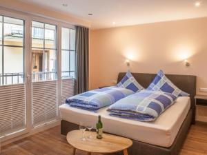 um quarto com uma cama com almofadas azuis e uma mesa em Das Gästehaus in Valwig em Valwig