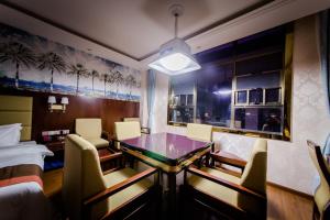 a dining room with a table and chairs and a bedroom at JUN Hotels Hunan Changsha Huannghua Airport in Changsha