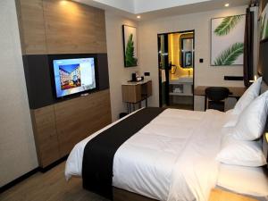 Habitación de hotel con cama y TV de pantalla plana. en Up And In Shan'xi Xi'an Weiyang District Yangguang Beijun en Xi'an