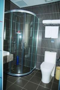 a bathroom with a shower with a toilet and a sink at Thank Inn Chain Hotel Tianjing Jingnan District Balitai Town Industrial Park in Tianjin
