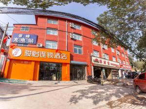 um edifício vermelho com escrita na parte da frente em JUN Hotels Shanxi Taiyuan Yingze District Chaoyang Street Store em Taiyuan