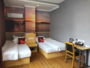 um quarto com 2 camas e uma secretária com uma secretária. em JUN Hotels Jiangxi Nanchang Xiyuan em Nanchang
