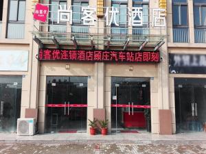 a building with a sign on the front of it at Thank Inn Chain Hotel Taizhou Dainan Guzhuang Village Bus Station in Taizhou