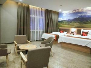 a hotel room with two beds and a painting on the wall at JUN Hotels Gansu Zhangye Linze County Bus Station in Zhangye