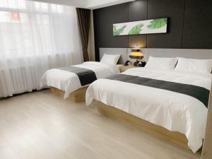 um quarto de hotel com duas camas e uma janela em Up and In Hebei Hengshui Taocheng District Baoyun Avenue em Hengshui