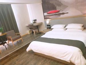 a hotel room with a large bed and a table at Thank Inn Plus Hotel Jiangsu Suzhou Taicang Liuhe Town Tinghai Road in Taicang