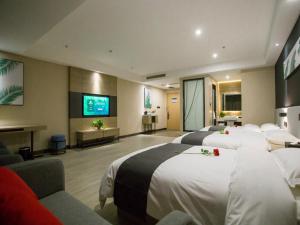 a hotel room with four beds and a flat screen tv at Up and In Shanxi Taiyuan Zonggai Shifanqu in Taiyuan