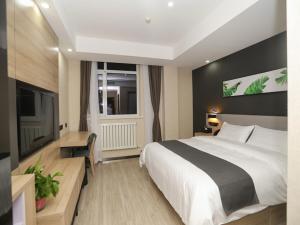 um quarto de hotel com uma cama grande e uma televisão em Up and In Hebei Hengshui Taocheng District Baoyun Avenue em Hengshui