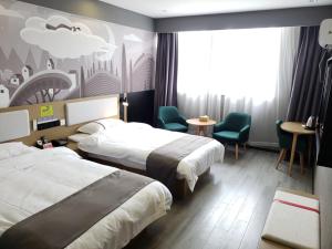 um quarto de hotel com duas camas e uma mesa e cadeiras em Thank Inn Chain Hotel Anhui Anqing Yixiu District Government University Town em Anqing