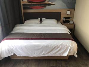 a bedroom with a large bed with white sheets at Thank Inn Chain Hotel Jiangsu Nanjing Jiangning Taowu in Nanjing +1 photo