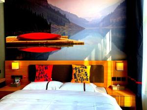 a bedroom with a large painting of a lake at JUN Hotels Tianjin Jinnan District University City Pingfan Road in Tianjin