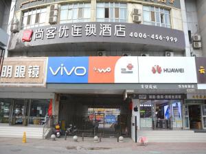 a building with a sign on the front of it at Thank Inn Chain Hotel Aksu Juche Tianwu Plaza in Kuqa