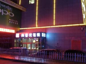 YushuにあるThank Inn Chain Hotel Qinghai Yushu County Kangba Commercial Cityの夜間の柵付きの建物