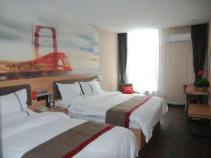 ein Hotelzimmer mit 2 Betten und einem Gemälde an der Wand in der Unterkunft Thank Inn Chain Hotel Tianjing Jingnan District Balitai Town Industrial Park in Tianjin