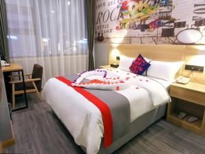 a bedroom with a large bed with a cake on it at JUN Hotels Sichuan Suining Chuanshan District Heping Road in Suining