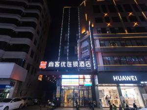 uma rua da cidade com edifícios altos à noite em Thank Inn Chain Hotel Guangdong Yunfu Xinxing County Times Square Store em Yunfu