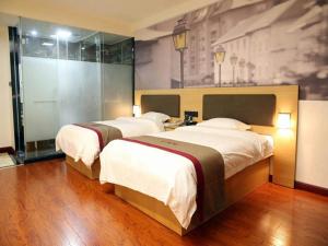 a hotel room with two beds and a painting on the wall at Thank Inn Chain Hotel Guangdong Heyuan Yuancheng District Heyuan Avenue North White Bailingtou Gaotang Store in Heyuan