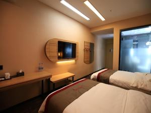 um quarto de hotel com duas camas e uma secretária e uma televisão em Thank Inn Chain Hotel Anhui Bengbu Huaiyuan County Huarun Suguo Store em Wuchazhen