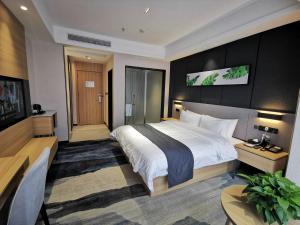 um quarto de hotel com uma cama grande e uma secretária em Up And In Ganzhou Zhanggong District Baoneng City em Ganzhou