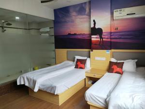 um quarto com duas camas e uma pintura de uma mulher montada num cavalo em JUN Hotels Jiangxi Nanchang Xiyuan em Nanchang