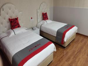 ein Hotelzimmer mit 2 Betten in rot und grau in der Unterkunft JUN Hotels Shanghai Chongming Xuegong Road Meizhou Road in Shanghai