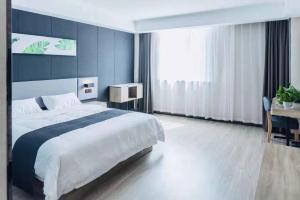 a large bedroom with a large bed and a desk at Up And In Qingdao Jimo District Aoshanwei Blue Silicon Valley in Qingdao