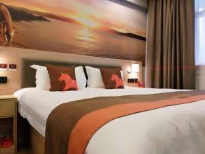 a hotel room with a large white bed with red horse pillows at JUN Hotels Shandong Zaohuang Tengzhou Jinghe West Road in Tengzhou