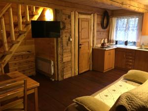 a room with a bed and a kitchen in a cabin at Mazurska Chatka in Zyzdrojowy Piecek