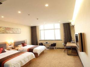 a hotel room with two beds and a desk at JUN Hotels Hebei Shijiazhuang Lingshou Zhongtian Commercial Building in Shijiazhuang