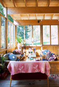 uma sala de estar com uma mesa e muitas janelas em Guesthouse Eleven Hotel em Arvika