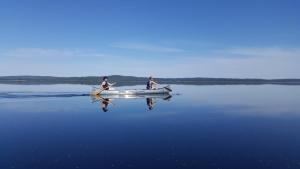 duas pessoas estão remando um barco na água em Guesthouse Eleven Hotel em Arvika