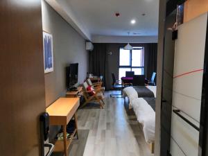 a hotel room with two beds and a living room at Up and In Hubei Xiaogan Yunmeng County Huguang Road 