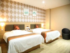 a hotel room with two beds in it at JUN Hotels Anhui Bangbu Guzhen County Huihe Road Store in Qiaokou