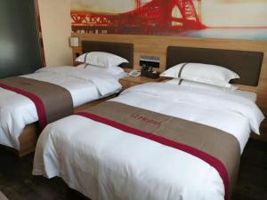 three beds in a hotel room with a red bridge at Thank Inn Chain Hotel Anhui Suzhou Lingbi County Qimeishan Road Store in Suzhou