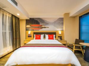 a bedroom with a large white bed with red pillows at Thank Inn Plus Hotel Guiyang Guanshan Lake District International Ecological Conference Center in Guiyang